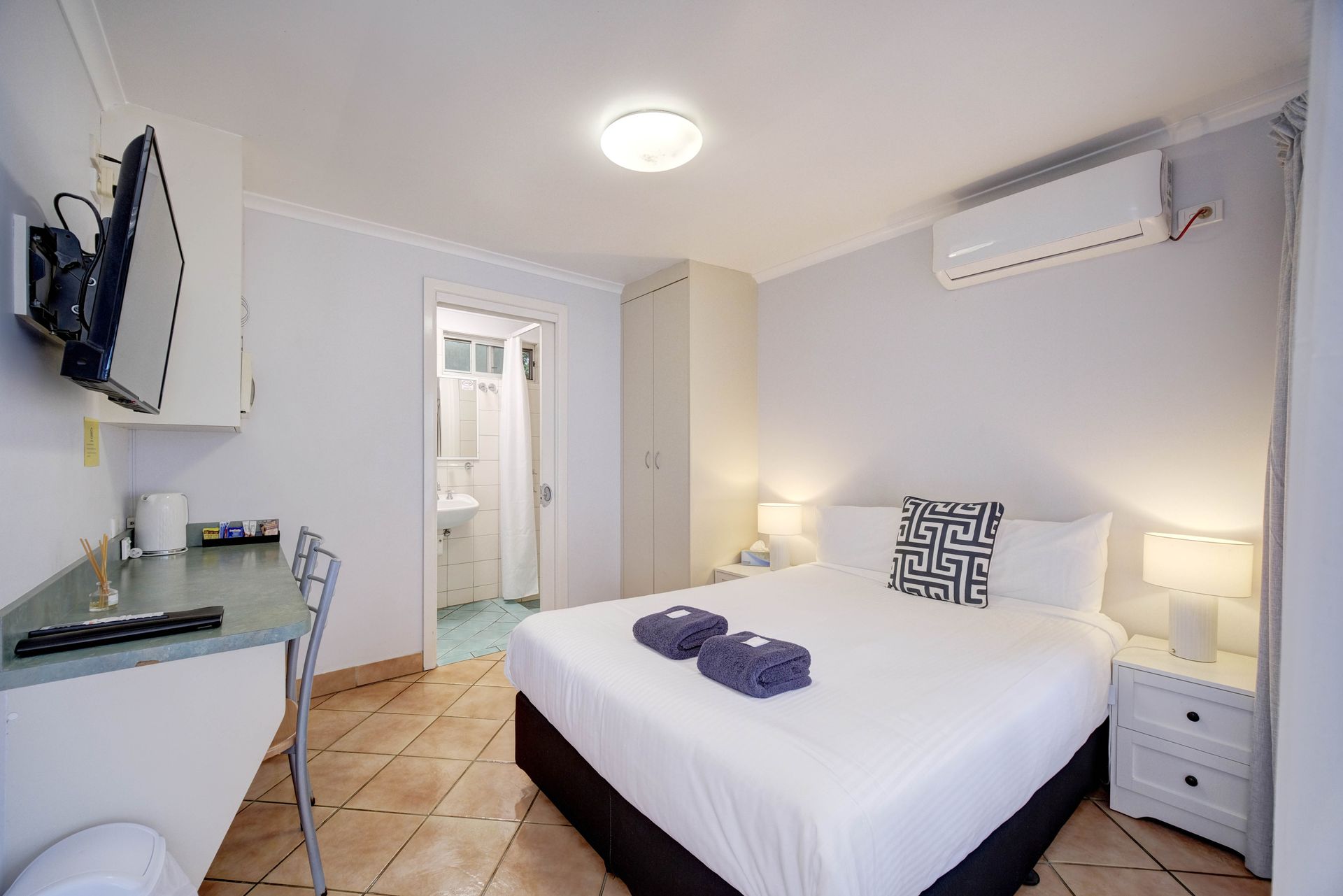 A Room With a Bunk Bed, a Desk, Chairs and a Mirror — Bali Hi Motel In Tuncurry, NSW