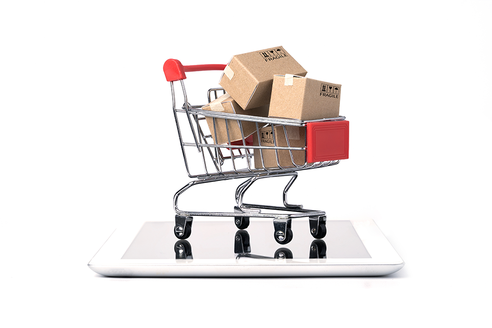 A shopping cart filled with boxes is sitting on top of a tablet.