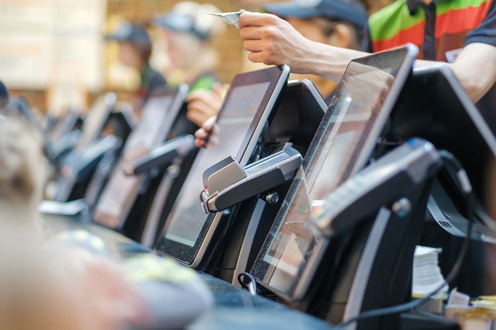 A person is using a credit card to pay at a fast food restaurant.