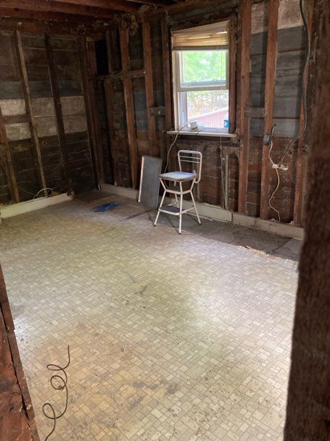 A room with a chair and a window in it.