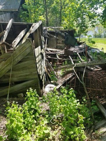 A pile of wood is sitting in the middle of a field.