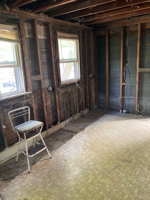 An empty room with a chair and a window.