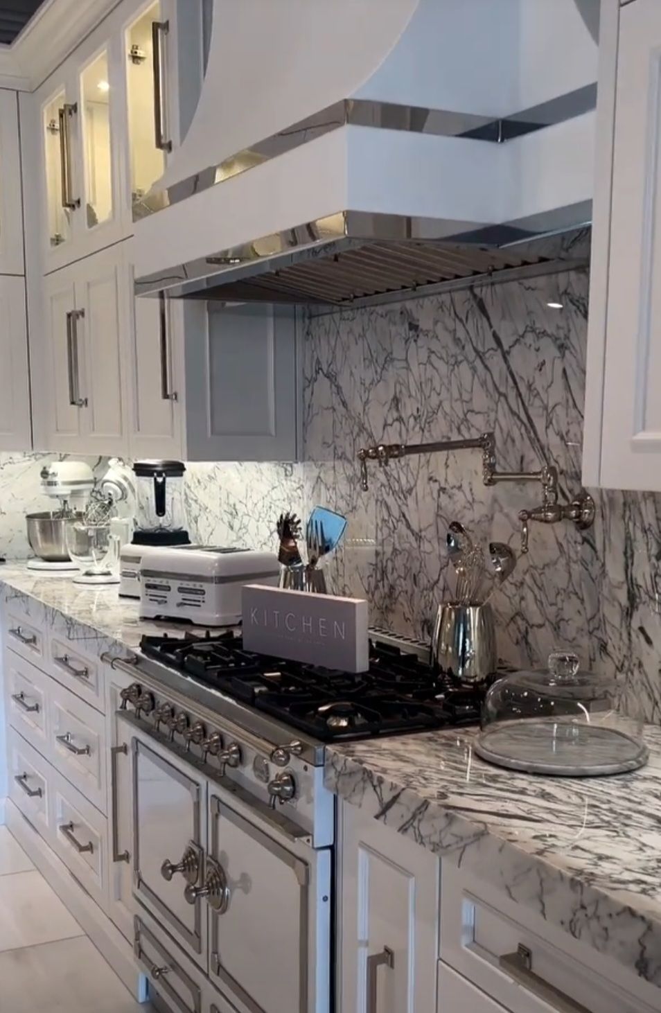 A kitchen with white cabinets and a stove top oven