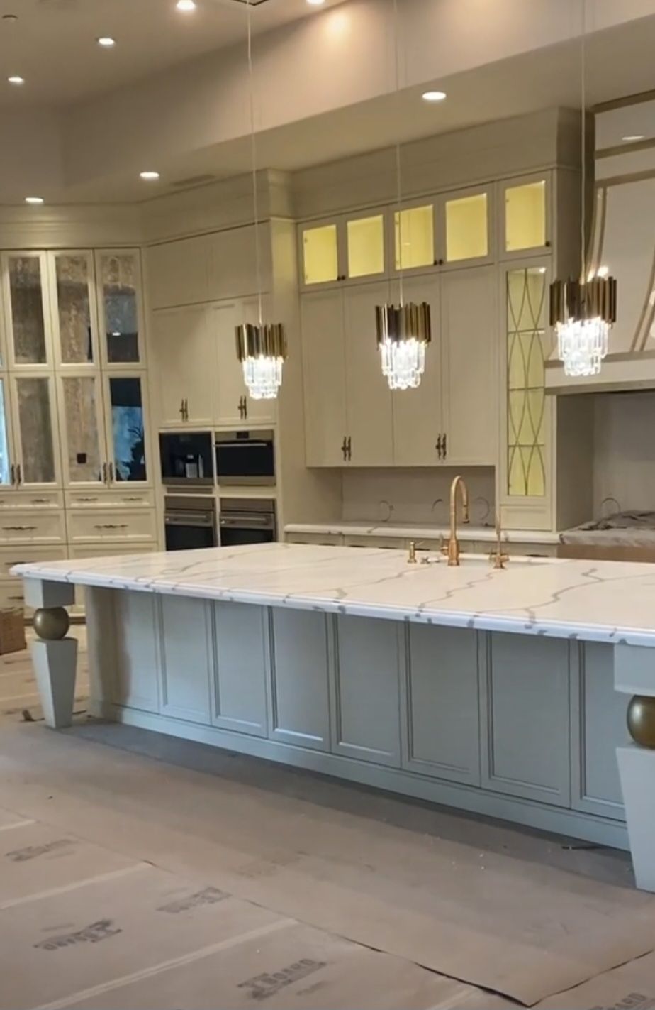 A kitchen with white cabinets and marble counter tops