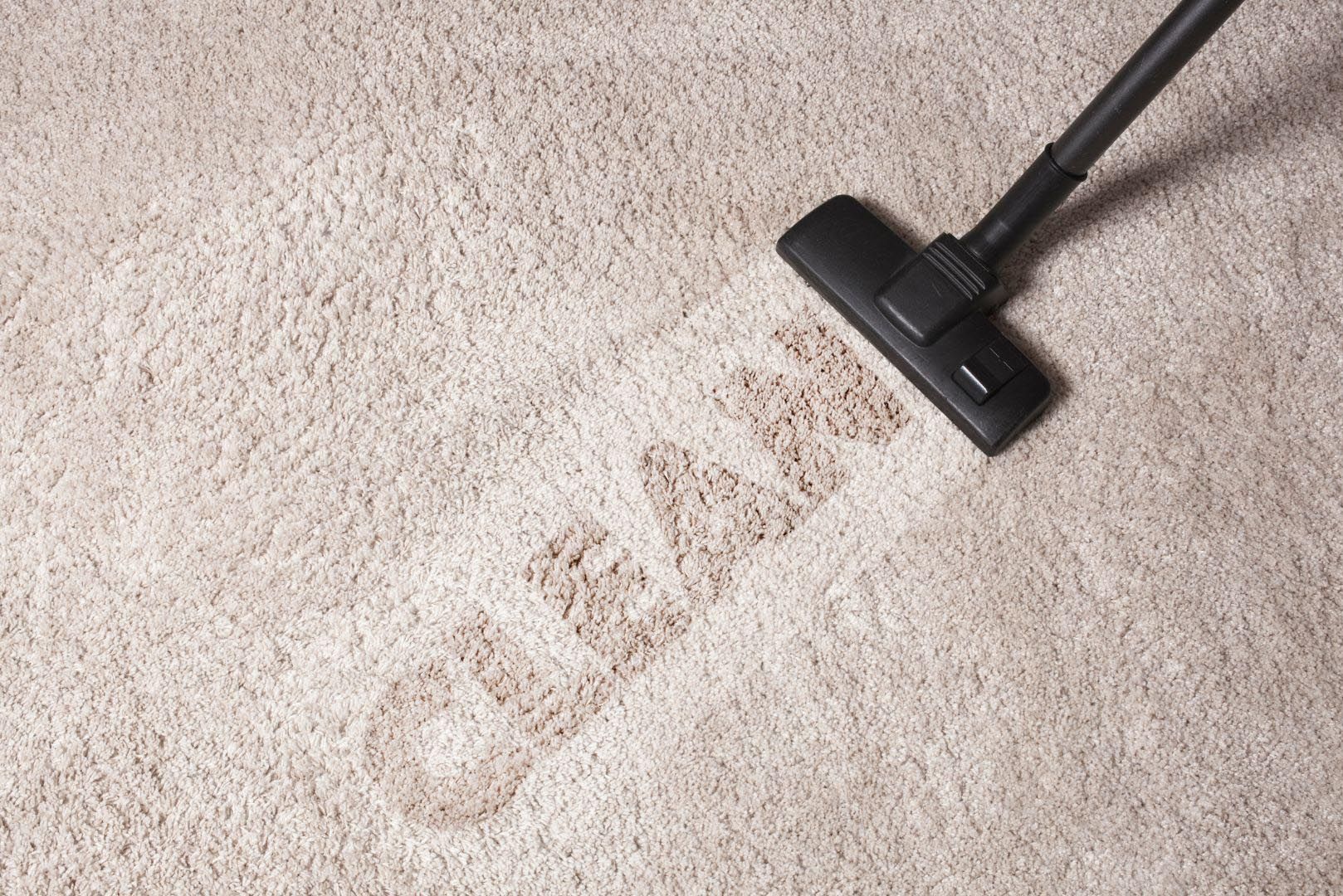 A vacuum cleaner is cleaning a carpet with the word clean written on it.
