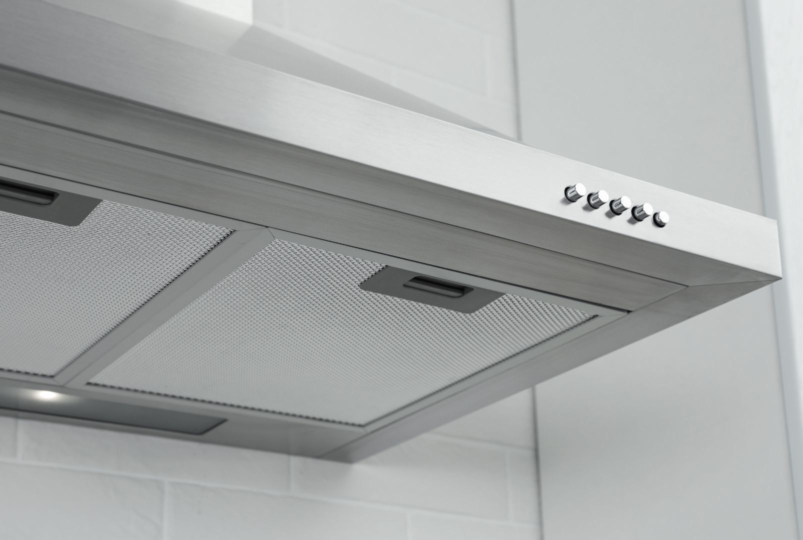 A close up of a stainless steel hood in a kitchen.