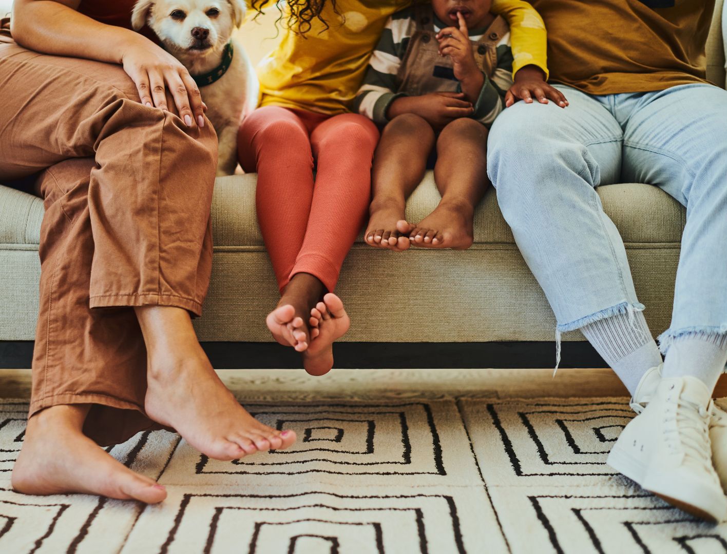 A family is laying on the floor in front of a couch.