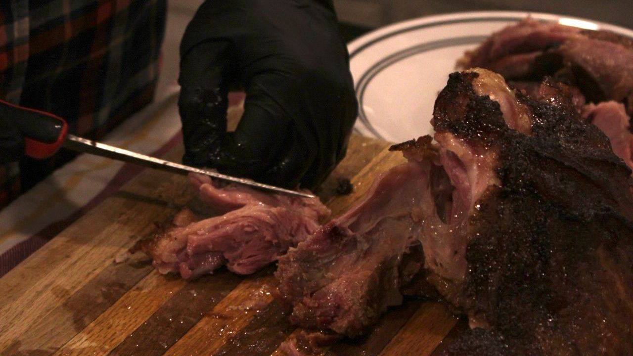 a person is cutting a piece of meat on a cutting board