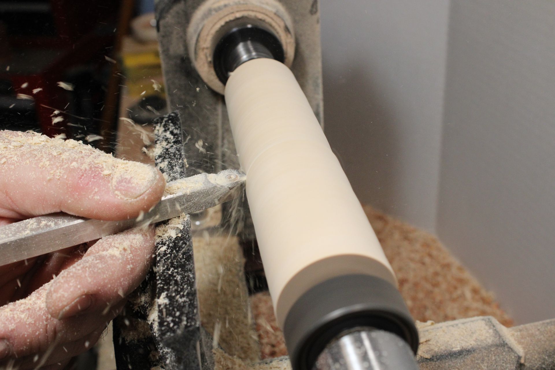 cutting a long piece of wood into a pestle
