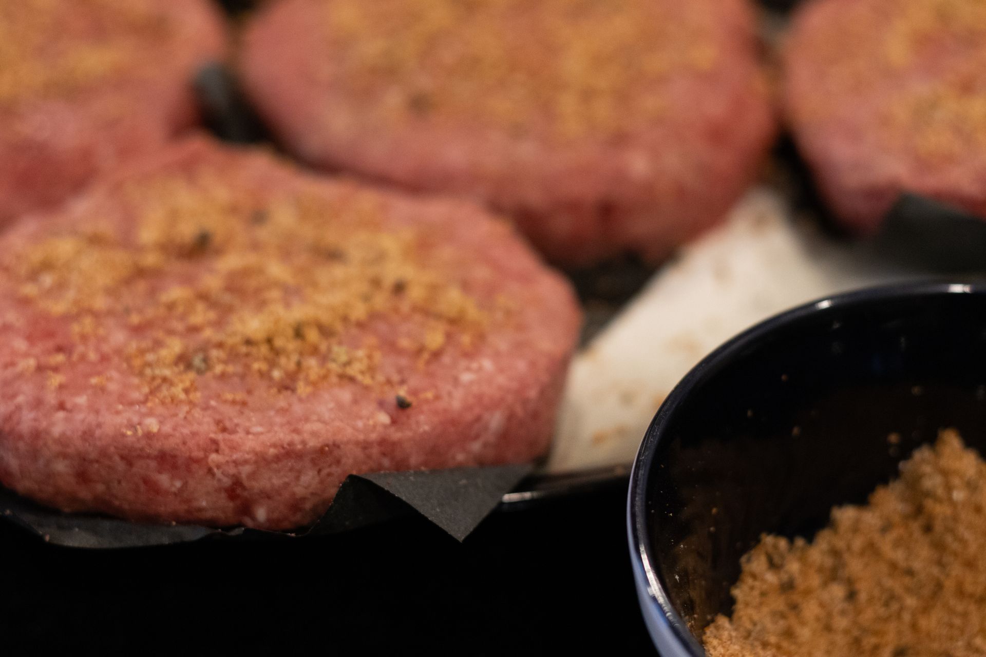 hamburger patties with sprinkled seasoning on top. 