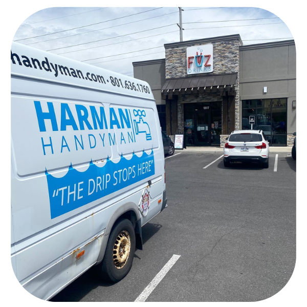 A Harman Handyman van parked in front of a building with a 