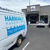A Harman Handyman van parked in front of a Fizz soda shop under a cloudy sky.
