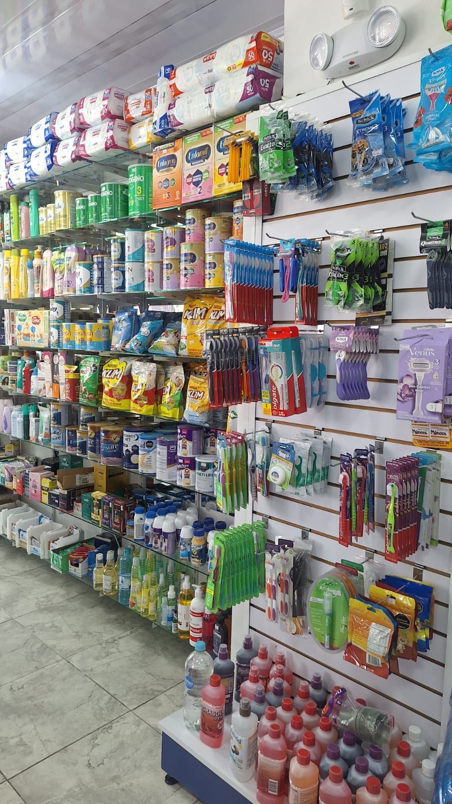 Una farmacia llena de papel higiénico, cepillos de dientes, champú y otros artículos.
