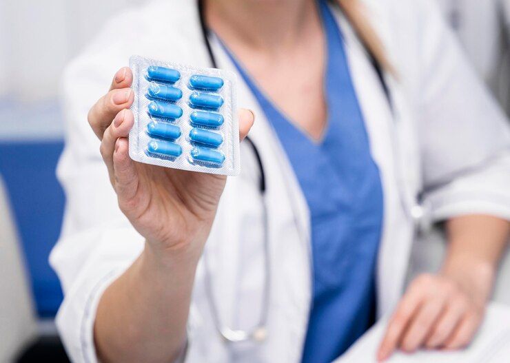 Un médico sostiene un blíster de pastillas azules.