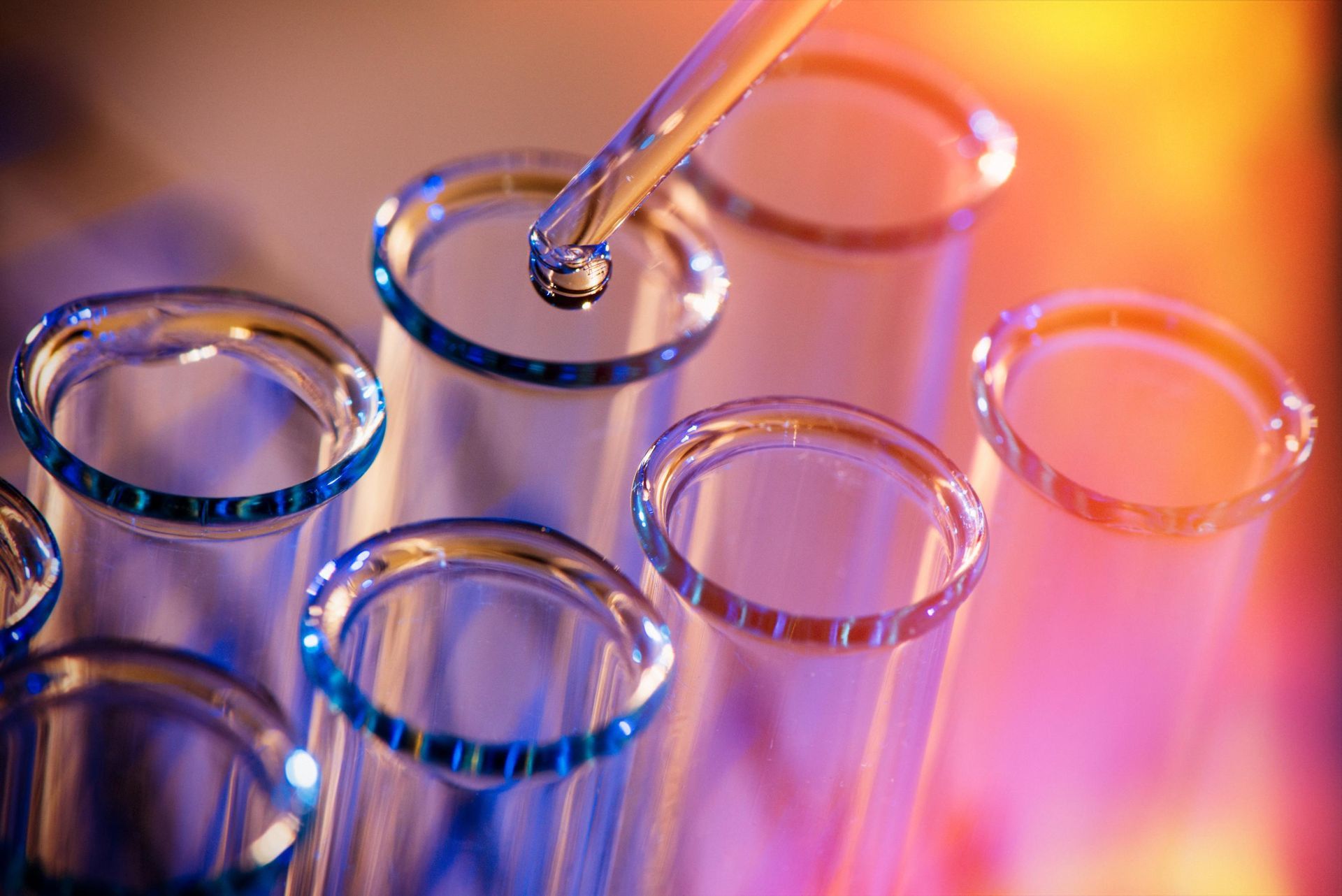 A drop of liquid is being poured into a test tube.