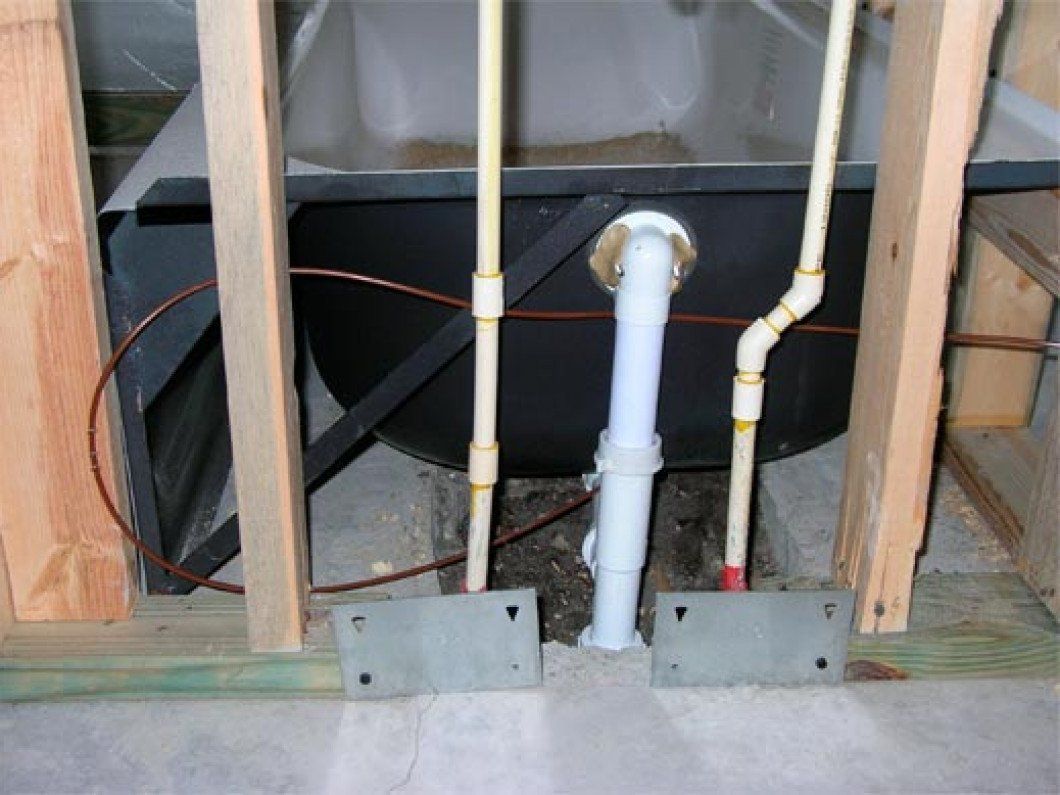 behind bathtub pipes and inner wall