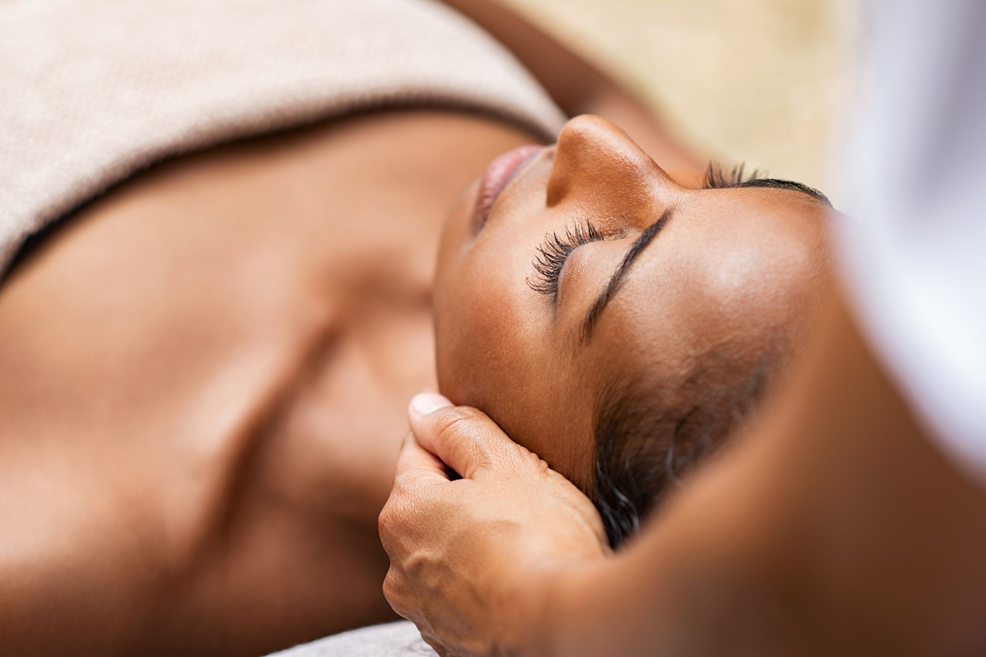 A woman is getting a head massage at a spa.