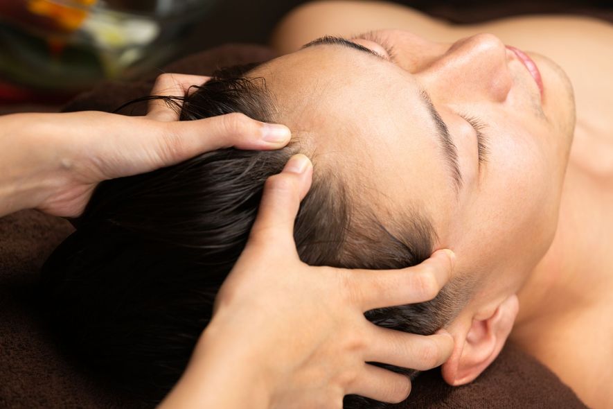 A man is getting a head massage at a spa.