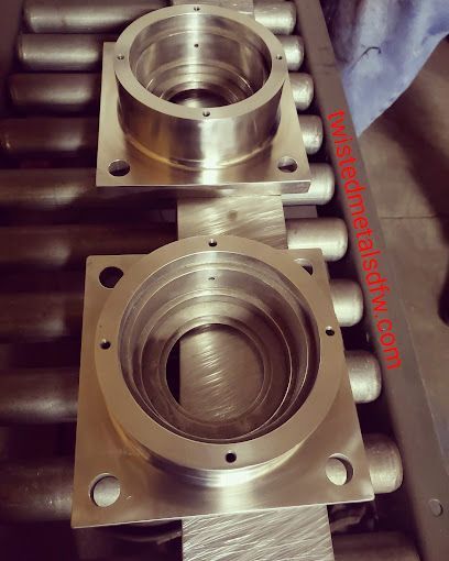 A large metal pipe is being rolled on a machine.