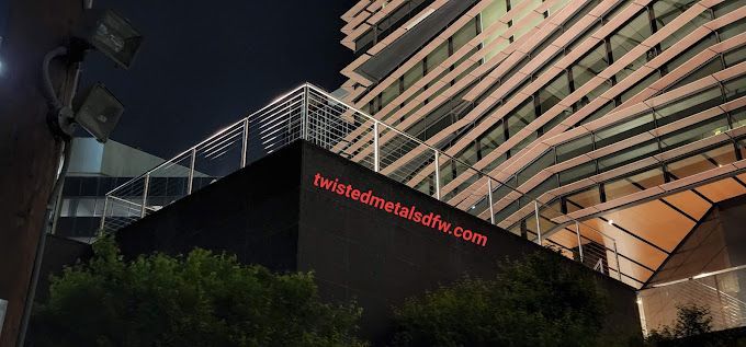 A construction worker wearing a yellow hard hat is welding a metal structure.