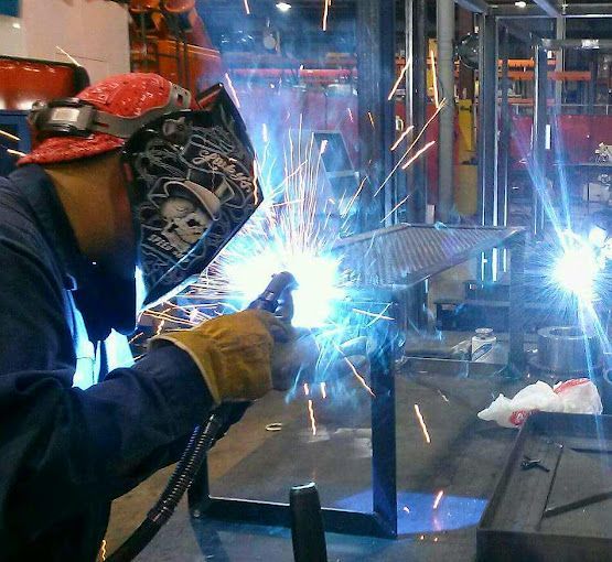 A man is welding a piece of metal in a car.