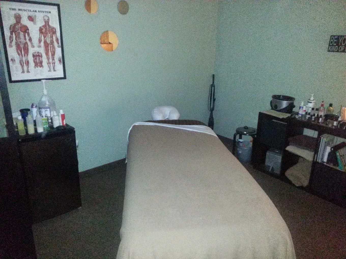 A massage table in a room with a poster on the wall