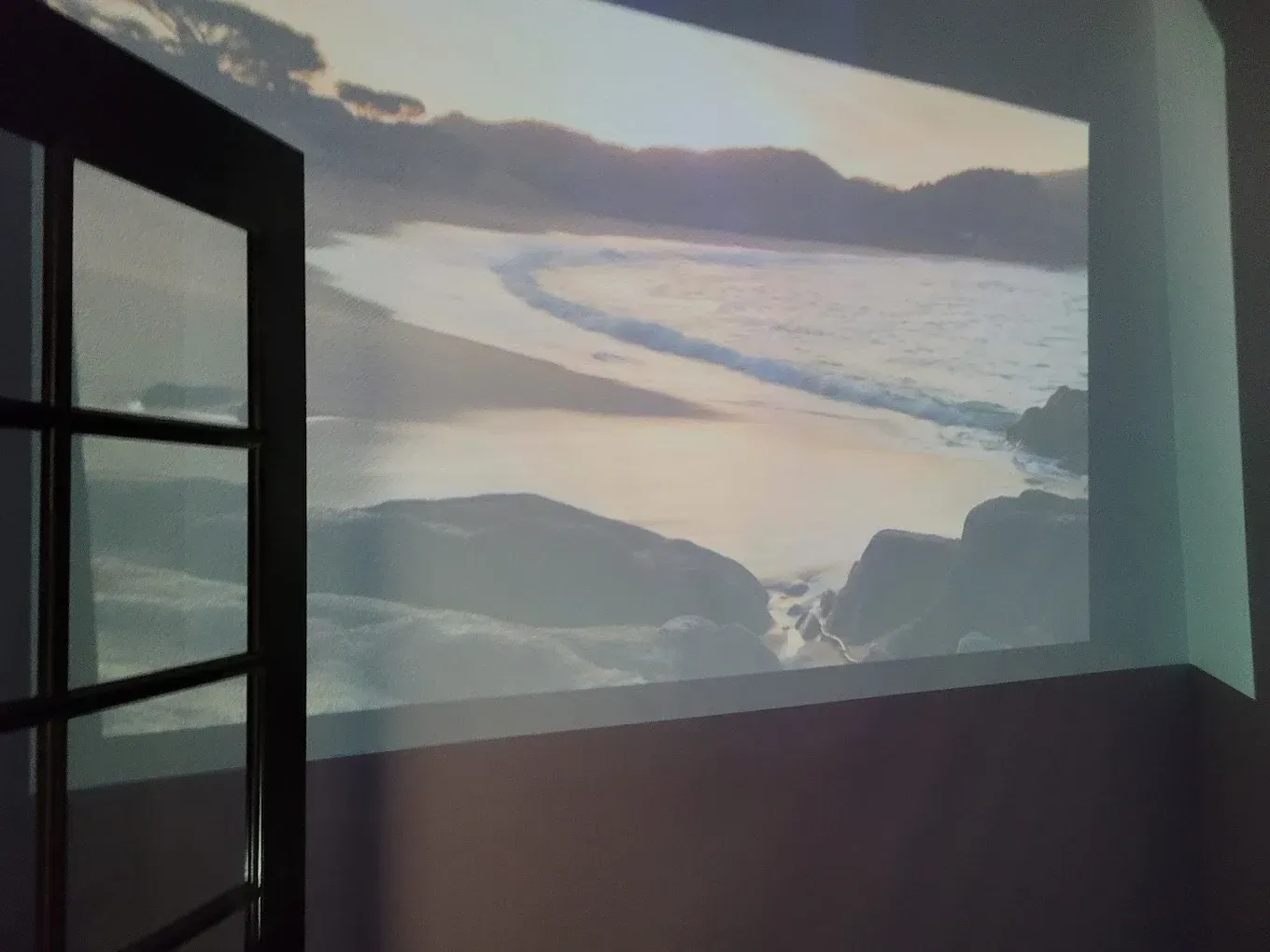 A picture of a beach is projected on a wall
