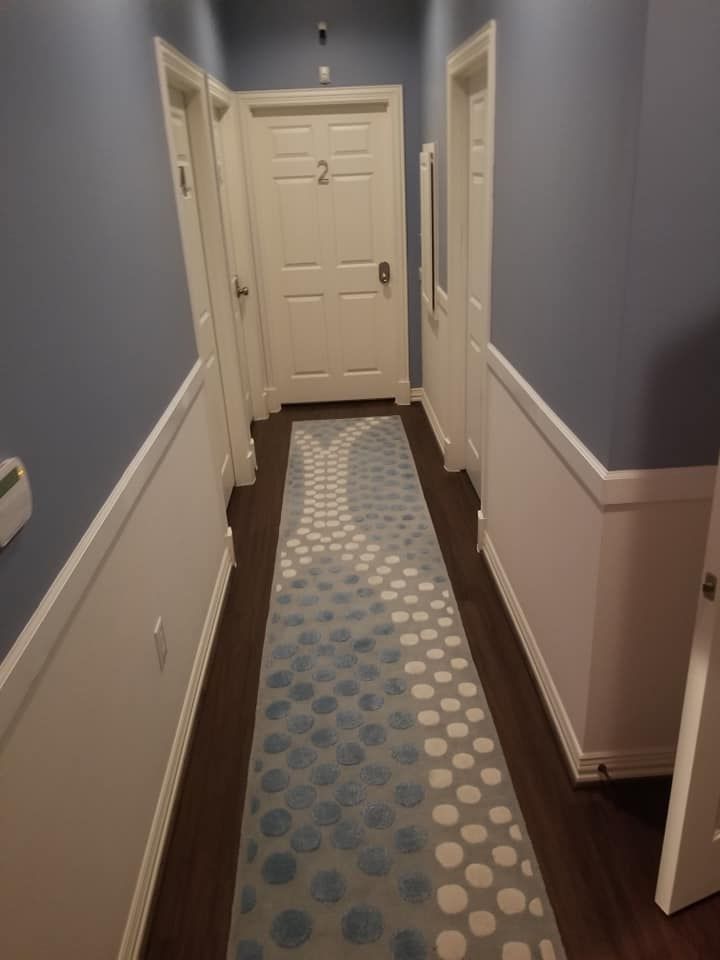 A hallway with a blue and white polka dot rug