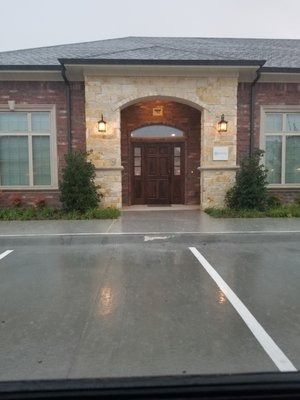A brick building with a parking lot in front of it.