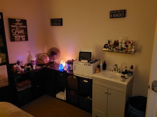 A room with a sink and a desk with a sign on the wall that says love