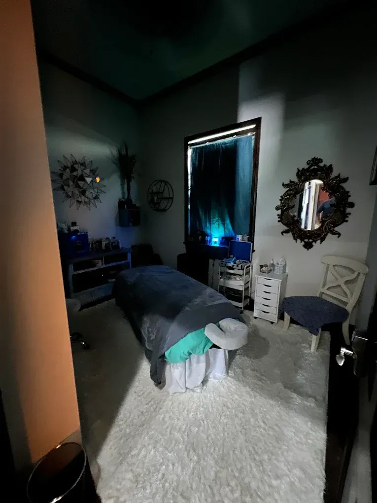 A room with a massage table and a mirror