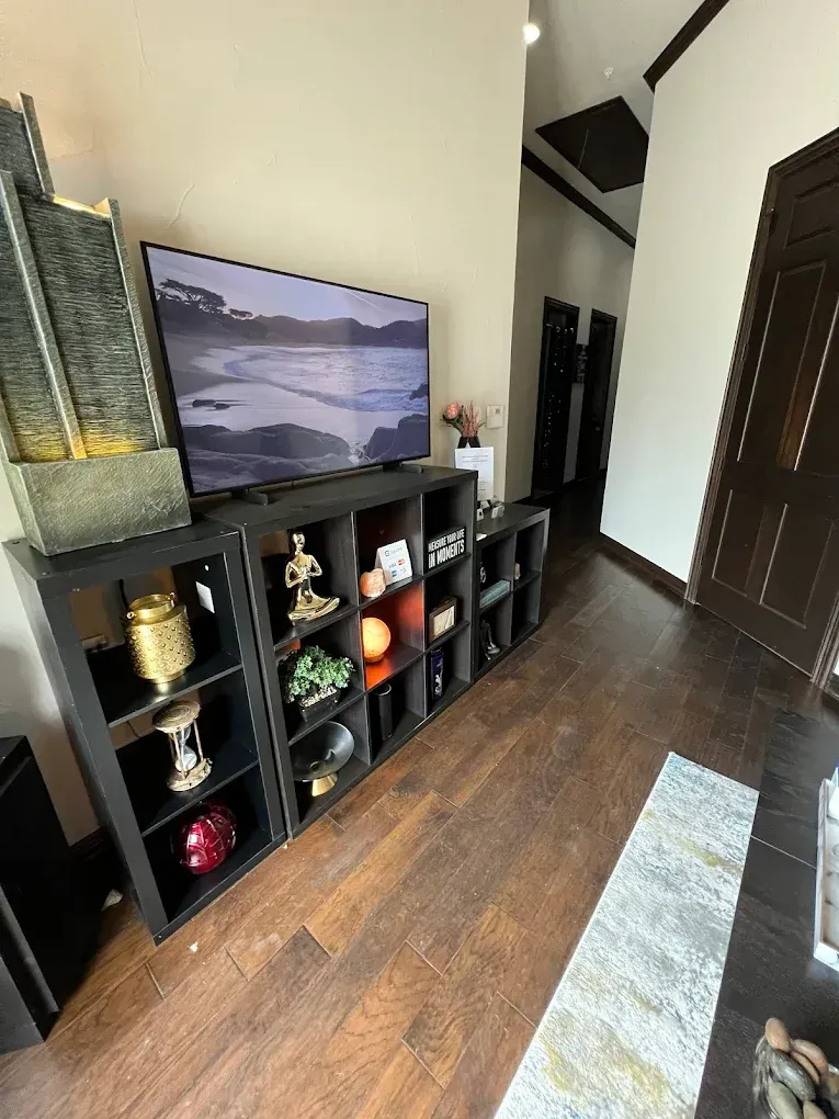 A living room with a flat screen tv on a shelf.