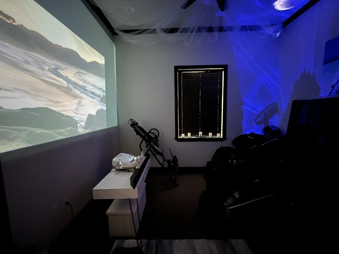A room with a projector screen and a window
