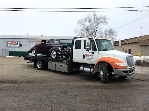 Towing Services in Lake Mills, WI by Topel’s Towing and Repair. Image of an orange-and-white tow tru