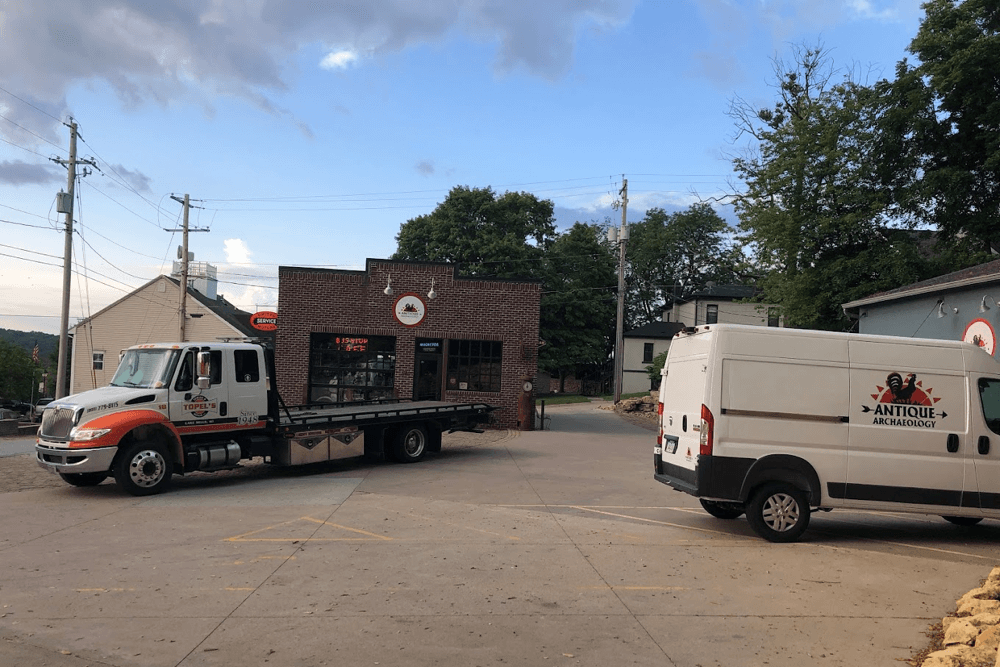 Fleet services in Lake Mills, WI with Topel’s Towing & Repair Inc. Image of Topel’s Towing tow truck in fleet client business parking lot with one of their fleet sprinter vehicles for repairs.
