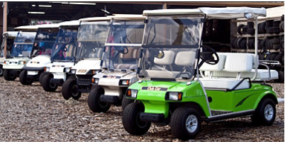 A row of golf carts are parked next to each other