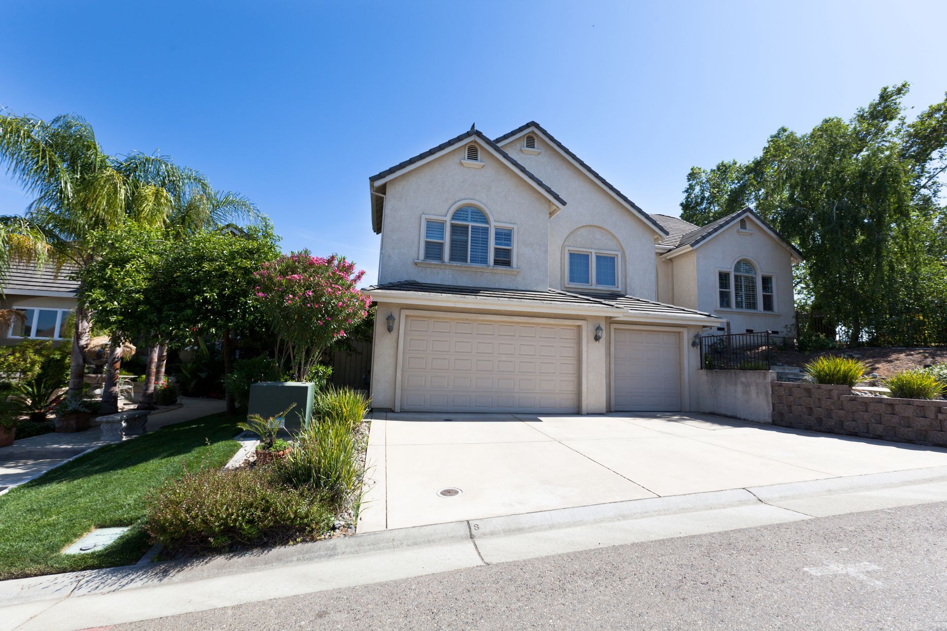 A large white house with two garage doors and a driveway