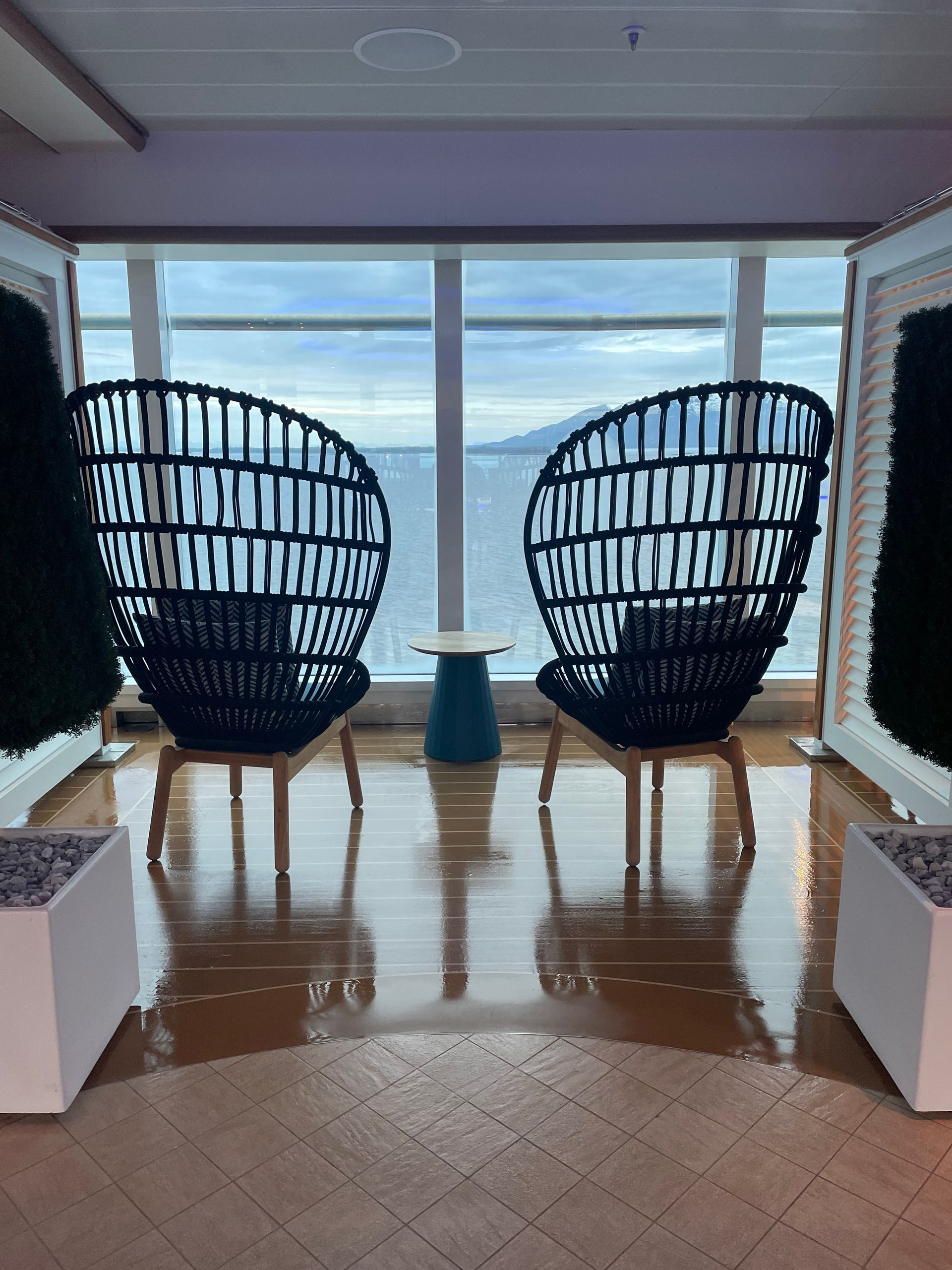 Two high back chairs facing the ocean on a cruise ship
