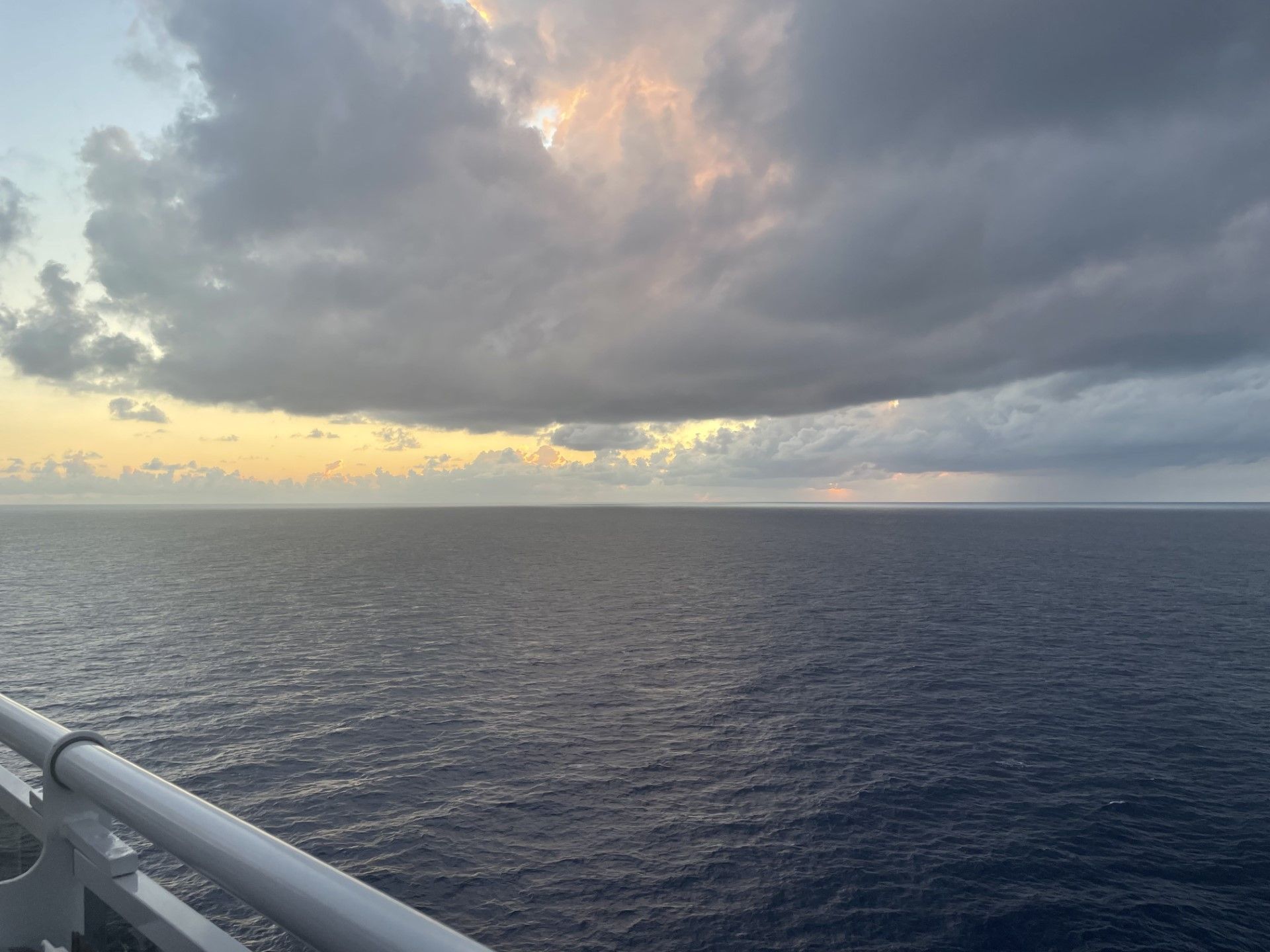 The sun is shining through the clouds over the ocean.