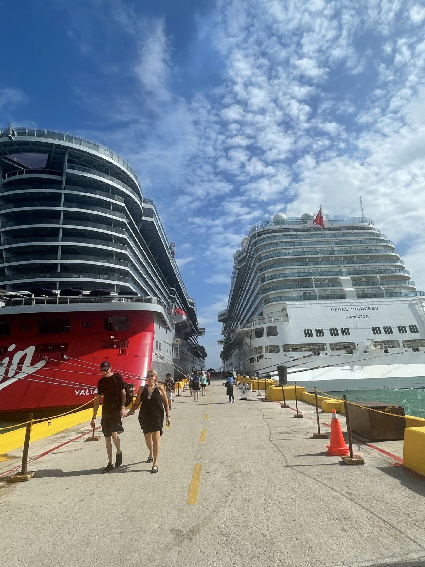 The aft view of two cruise ships from the pier. Featuring Virgin Voyages and Princess Cruises
