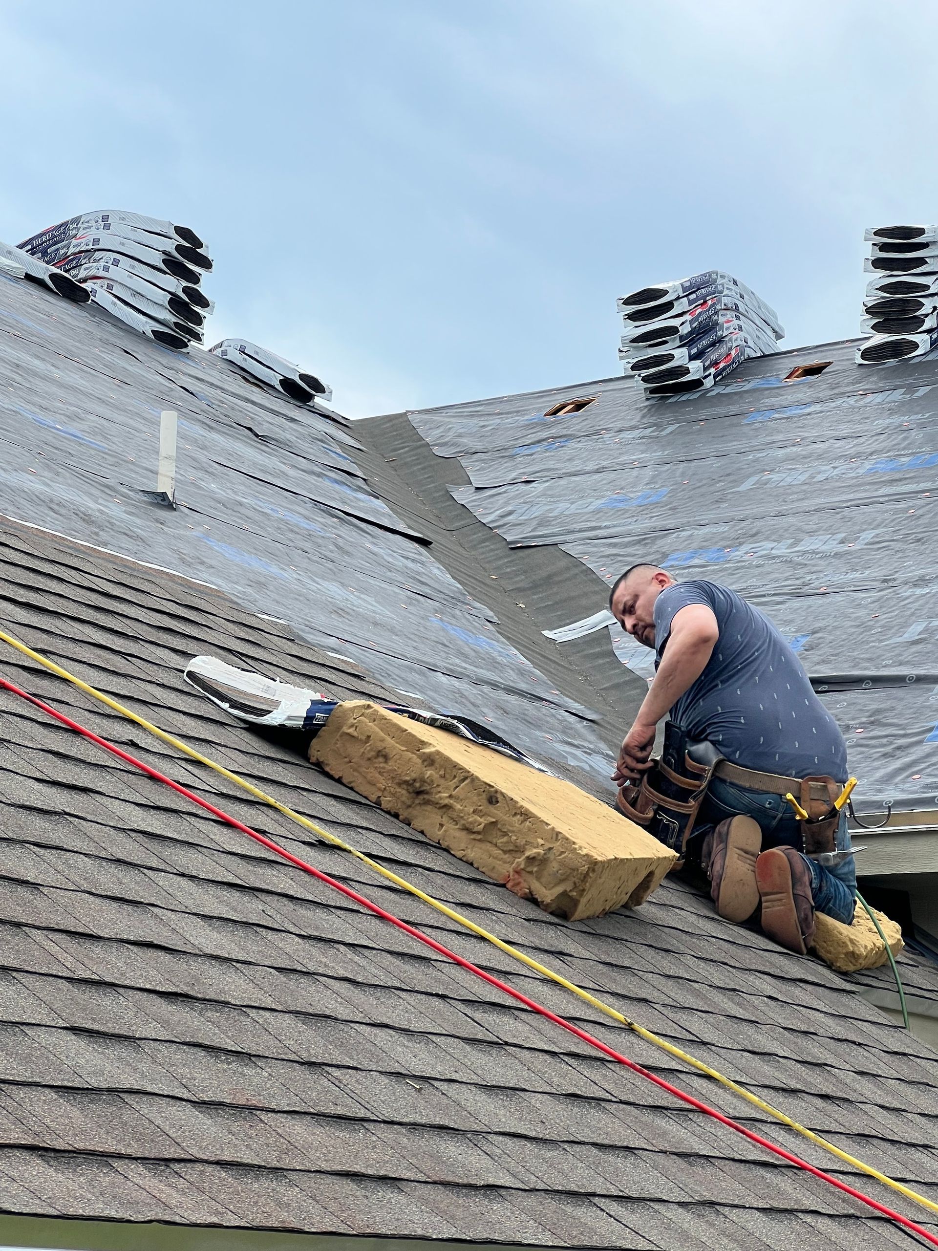 A man is working on the roof of a house.