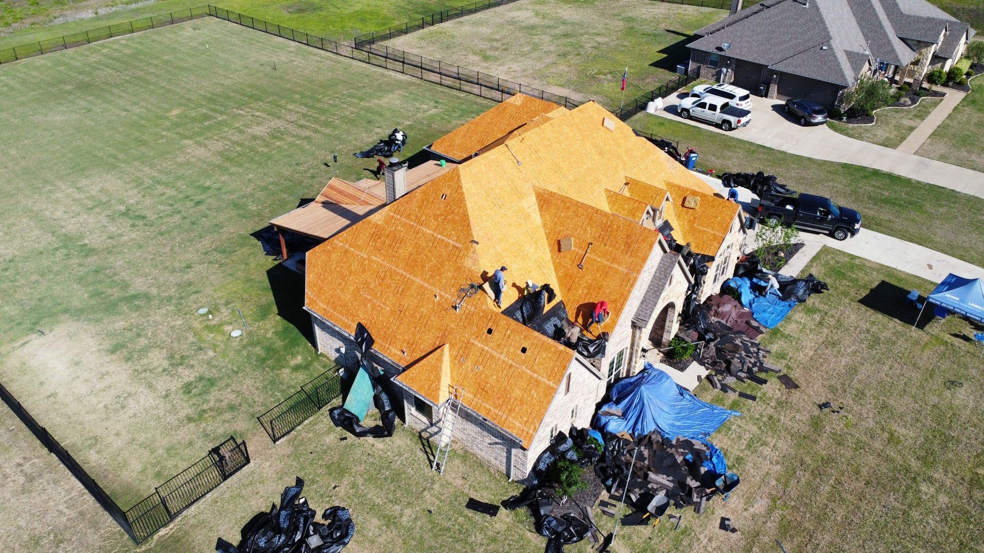 An aerial view of a house with a new roof being installed.