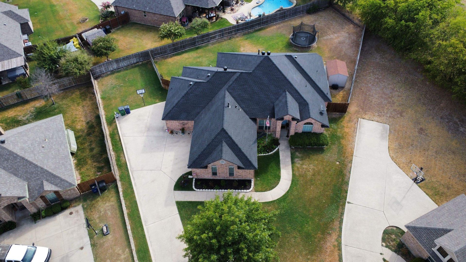 An aerial view of a house with a pool in the backyard.