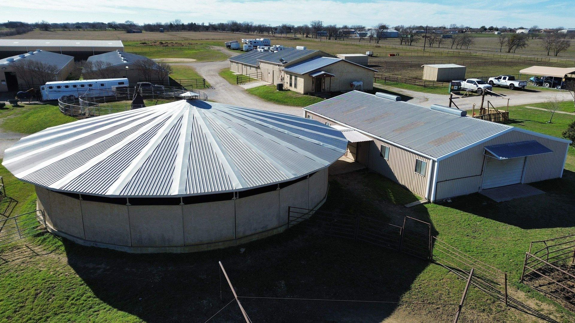 An aerial view of a farm with a large round building in the middle.