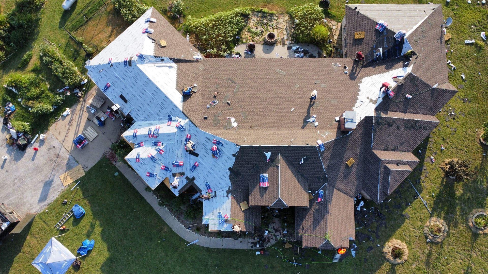 An aerial view of a house being remodeled with a roof being installed.