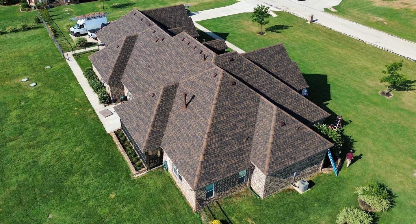 An aerial view of a house with a roof that is covered in shingles.