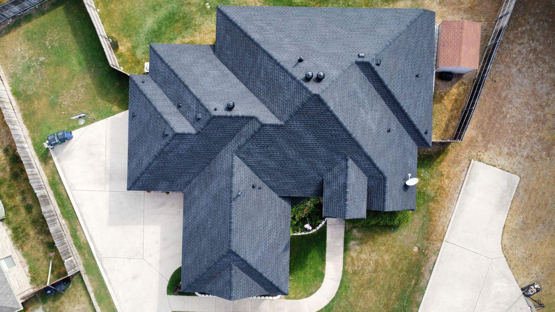 An aerial view of a house with a roof and a driveway.