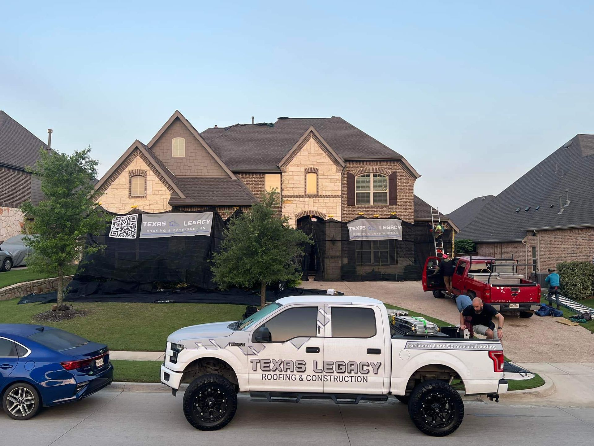 A white truck is parked in front of a large house.