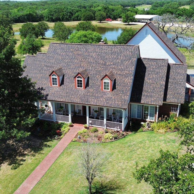An aerial view of a house with a lake in the background
