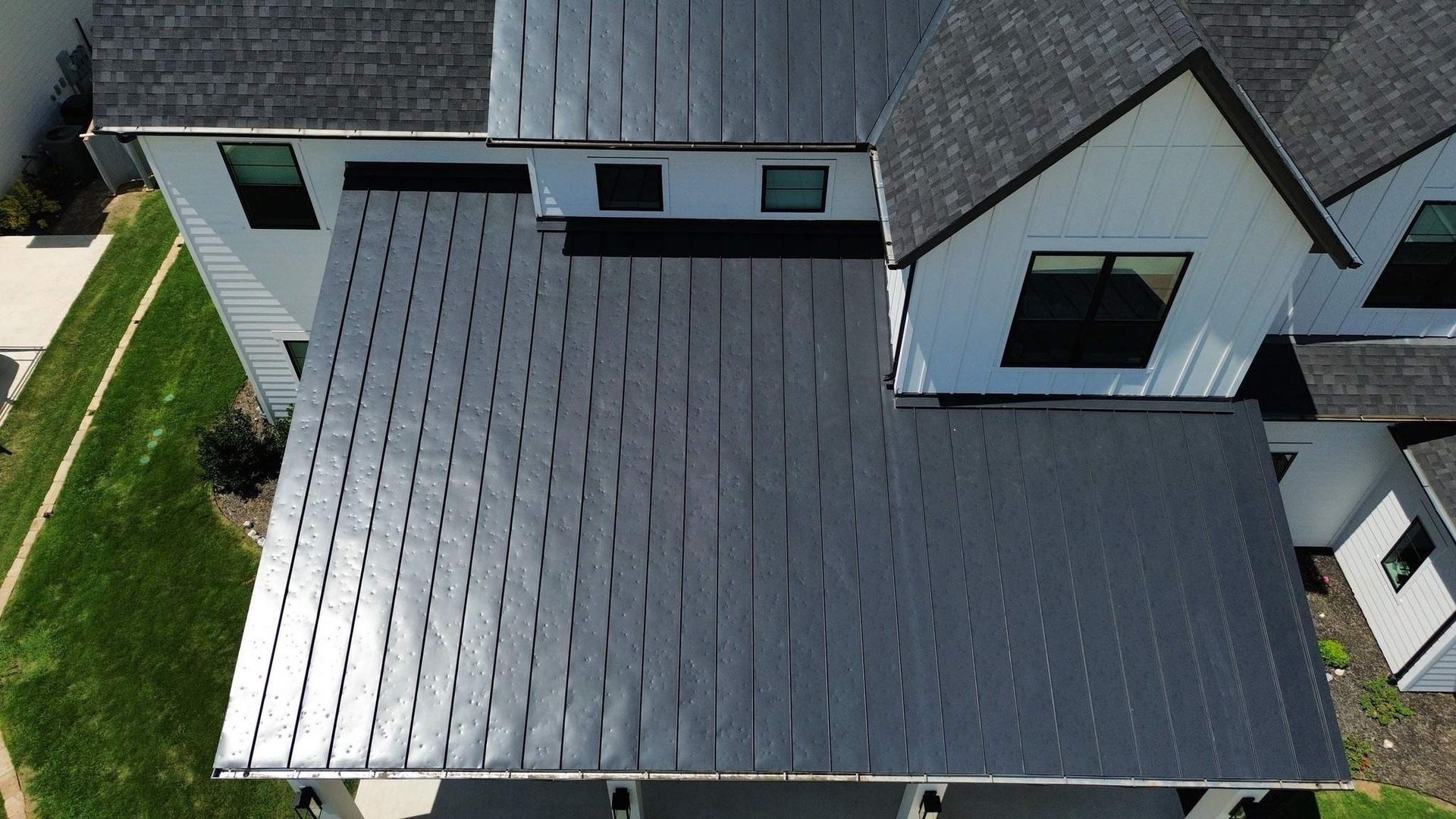 An aerial view of a house with a black roof.
